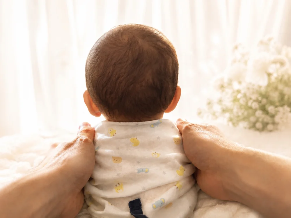 主催者の子どもの後ろ姿。かすみ草のある明るい窓辺で